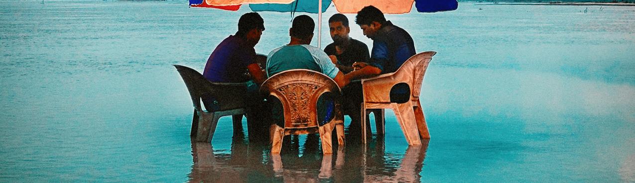 Men sitting in a laguna with table and umbrella